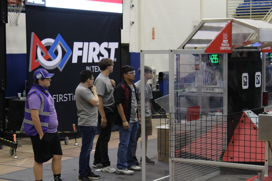 Hudson Stingers drive team discussing robot performance