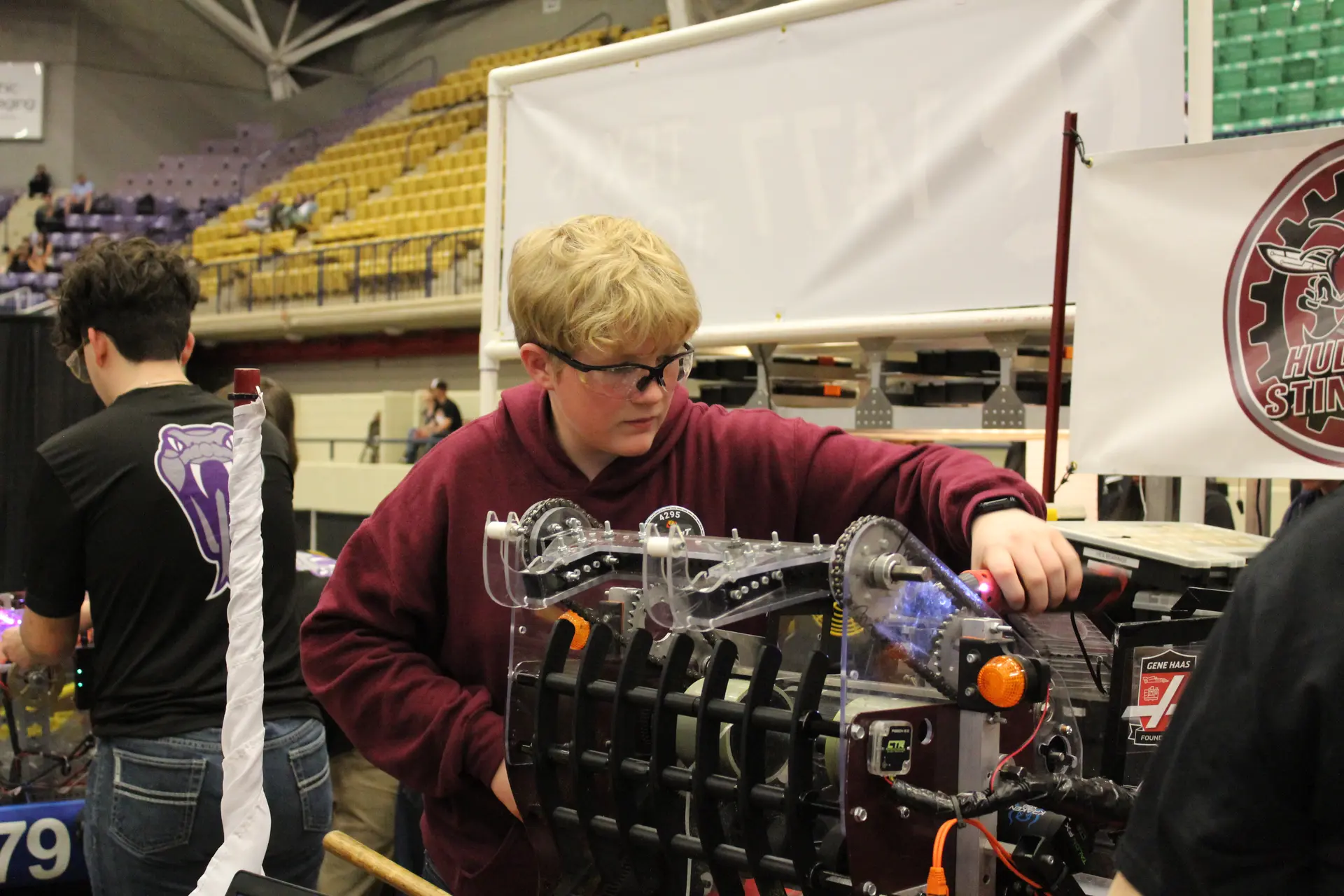 FRC Team 4295 Hudson Stingers students working on robot in the pits
