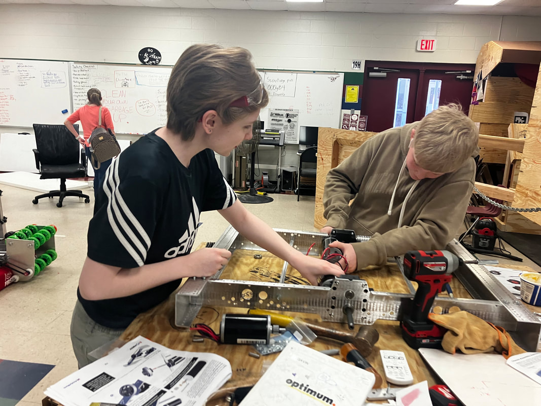Hudson Stingers robotics team installing motors on FRC robot