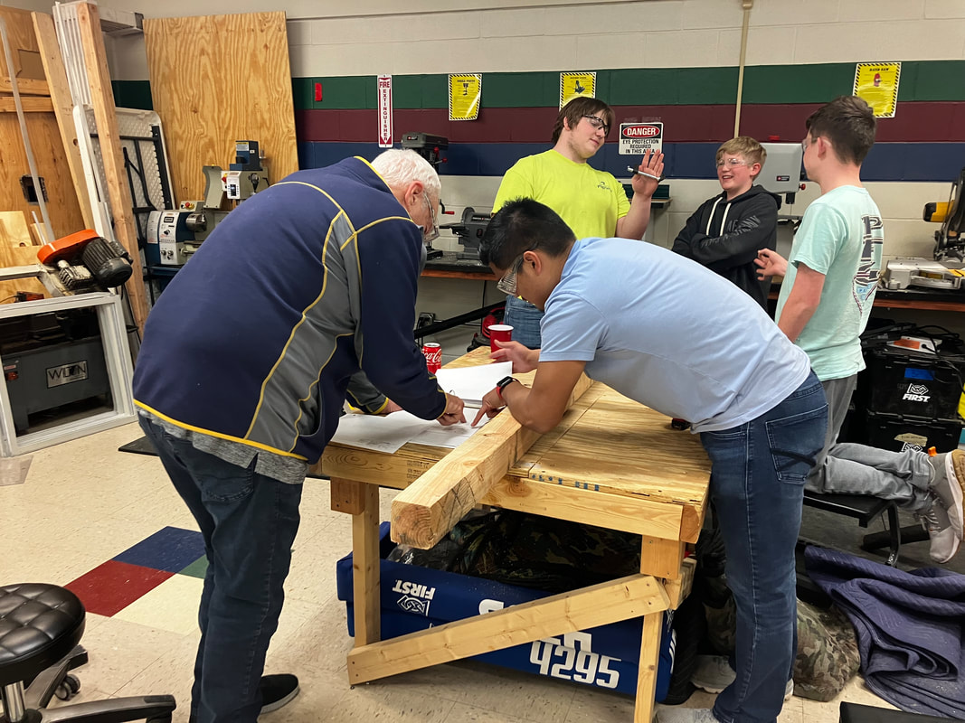 Hudson Stingers robotics team reviewing robot design plans